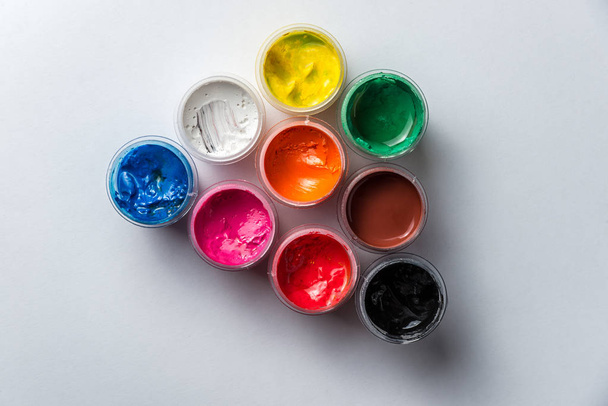 latas pequeñas con coloridas pinturas gouache y borlas para todo el marco. Marco horizontal
 - Foto, imagen