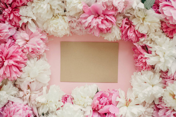 Peonías rosas y blancas con tarjeta vacía sobre papel rosa pastel. Copiar espacio. Elegante piso creativo laico. Feliz día de las madres, maqueta de tarjetas de felicitación floral. Día Internacional de la Mujer. Día de San Valentín
 - Foto, imagen
