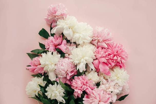 Μπουκέτο με παιώνια κομψή επίπεδη θέσει. Ροζ και λευκές παιώνιες σε παστέλ ροζ χαρτί. Γεια σας την άνοιξη. Ευτυχισμένος μητέρες ημέρα, floral ευχετήρια κάρτα κοροϊδεύω. Διεθνής ημέρα γυναικών. Ημέρα του Αγίου Βαλεντίνου - Φωτογραφία, εικόνα