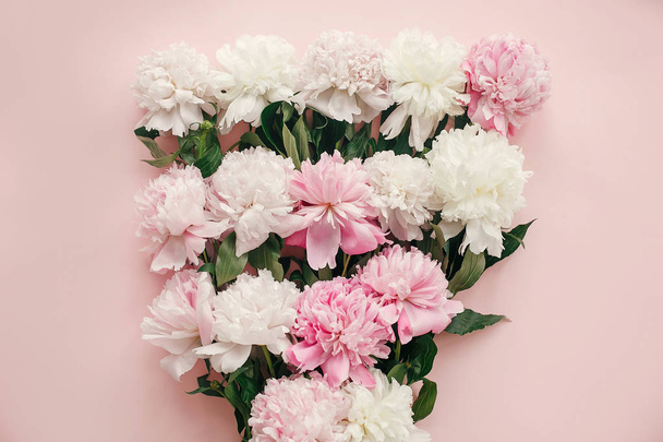 Witam wiosna. Piwonie stylowy bukiet płaskie leżał. Różowe i białe piwonie na pastelowy różowy papier. Matek szczęśliwy dzień, kwiatów z życzeniami makieta. Międzynarodowy Dzień kobiet. Walentynki - Zdjęcie, obraz