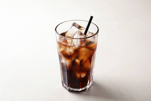 Glass of refreshing cola with ice on white table - Foto, Imagem