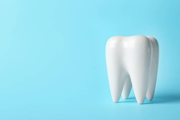Ceramic model of tooth on color background. Space for text - Foto, afbeelding