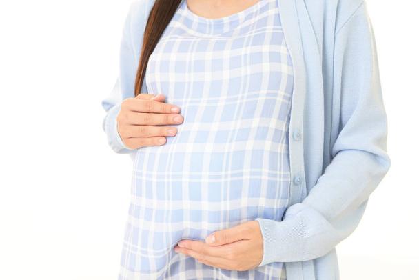 Donna incinta toccando pancia contro sfondo bianco
 - Foto, immagini