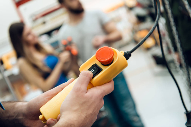 Verkoper is het controleren van contorl panel van apparaat in power tools winkel. - Foto, afbeelding