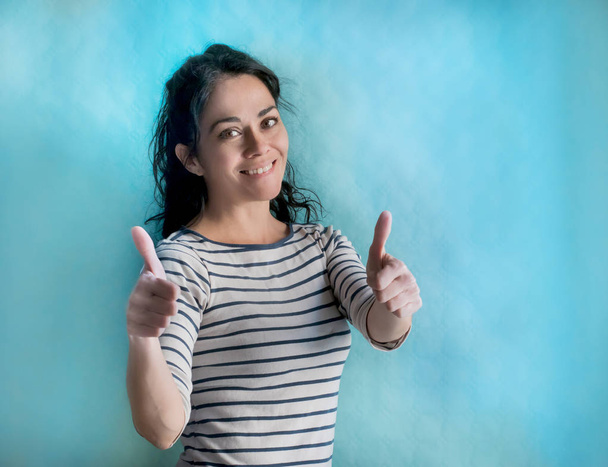 Brunette woman over isolated background doing happy thumbs up gesture with hands. Approving expression looking at the camera with showing success - Photo, Image