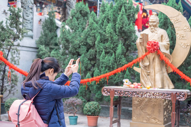 Mujer joven ata cuerda roja y rezar en Yue Lao (Dios del matrimonio) en el templo de Wong Tai Sin, es bien conocido por el amor y las oraciones de matrimonio respondidas. hito y popular para las atracciones turísticas en Hong Kong
 - Foto, Imagen