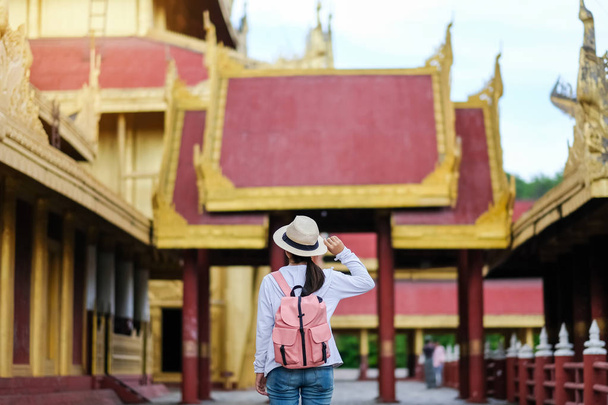 Mujer viajando mochilero con sombrero, viajero asiático de pie en Mandalay Palace, es el último palacio real de la última monarquía birmana. hito y popular para las atracciones turísticas en Myanmar
 - Foto, Imagen