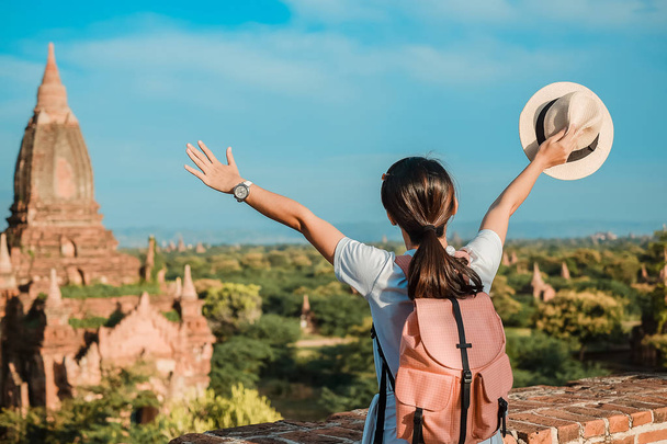 Giovane donna in viaggio zaino in spalla con cappello, viaggiatore asiatico in piedi su Pagoda e alla ricerca di bei templi antichi, punto di riferimento e popolare per le attrazioni turistiche a Bagan, Myanmar. Asia Viaggio concetto
 - Foto, immagini