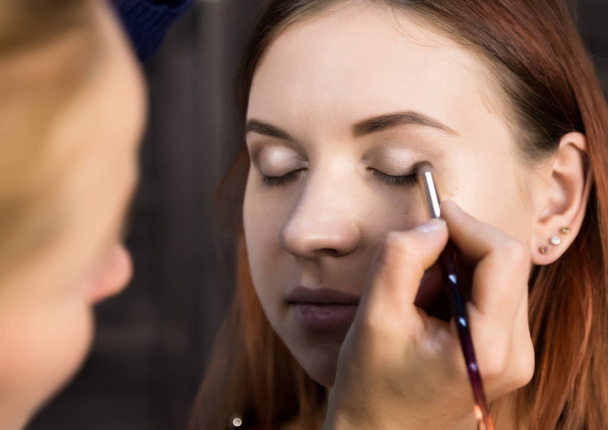 makeup artist preparing young beautiful woman. close-up eyeliner - 写真・画像