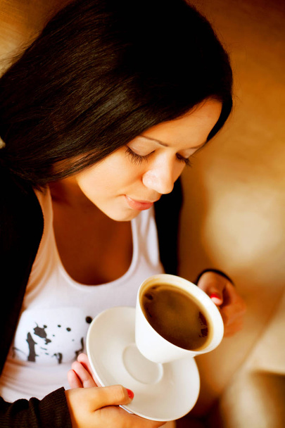 young woman sitting in a cafe drinking coffee - Photo, Image