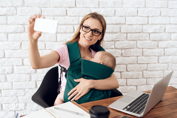 Smiling business woman with baby making selfie. - Foto, Imagem