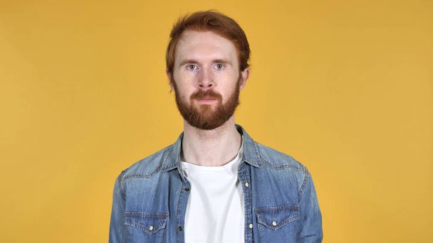 Redhead Man Looking at Camera Isolated on Yellow Background - Zdjęcie, obraz