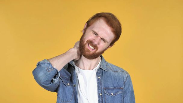 Vörös hajú ember, nyaki fájdalom, sárga háttér - Fotó, kép