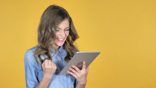 Genç kız heyecanlı başarı kullanarak Tablet izole sarı arka plan üzerinde süre için - Fotoğraf, Görsel