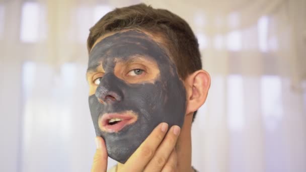 Portret van een man met een crème of klei masker op zijn gezicht. - Video
