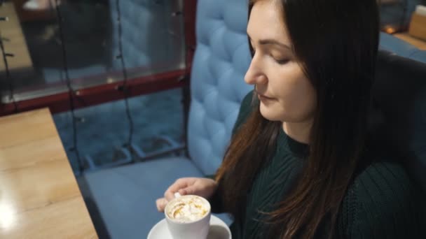 Aantrekkelijk meisje in een café koffie drinken - Video