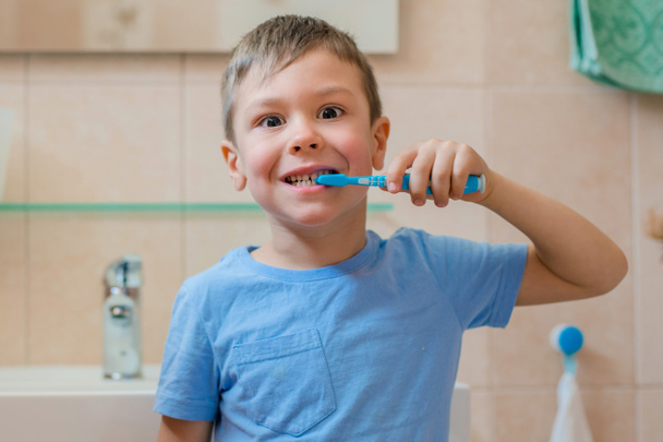 Happy kid or child brushing teeth in bathroom. Dental hygiene. - Foto, imagen