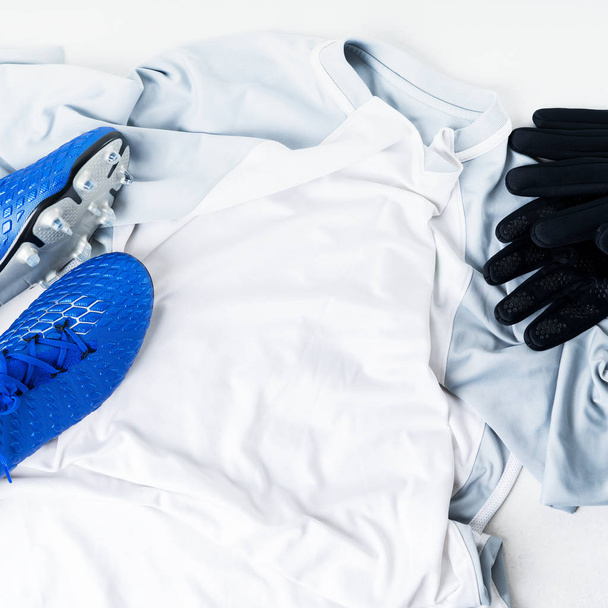 Blue football soccer boots cleats shoes and gloves on white t-shirt uniform - Φωτογραφία, εικόνα