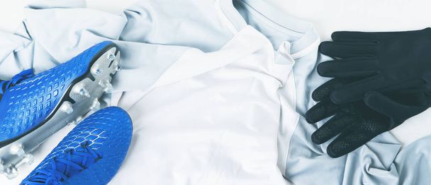 Blue football soccer boots cleats shoes and gloves on white t-shirt uniform - Fotó, kép