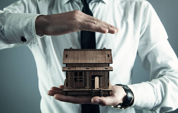 Realitní agent chránit dřevěný dům. Real estate koncept - Fotografie, Obrázek
