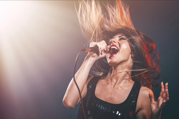 young woman singer in front of microphone singing with mouth wide open - Photo, Image