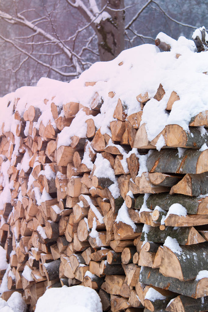 Chopped stock of firewood under snow outdoor - Fotografie, Obrázek