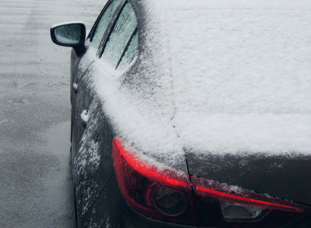 Снег и лед на задней части автомобиля на мокром асфальте
 - Фото, изображение