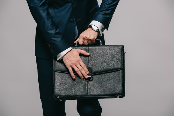 cropped view of businessman opening briefcase isolated on grey - Photo, Image