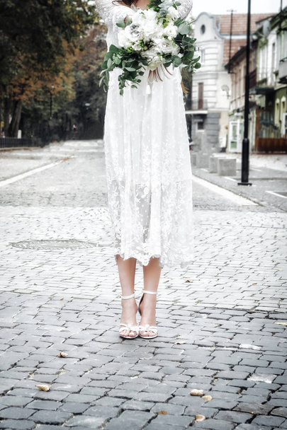 ヴィンテージのレースのドレスでエレガントなハイヒール サンダル ライムゼリー ユーカリ風味とブーケを持って花嫁。クローズ アップ, コピー スペース - 写真・画像
