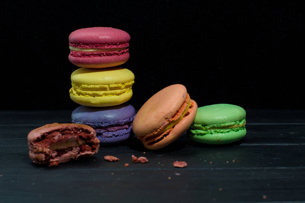 karanlık masada renkli macaroons - Fotoğraf, Görsel
