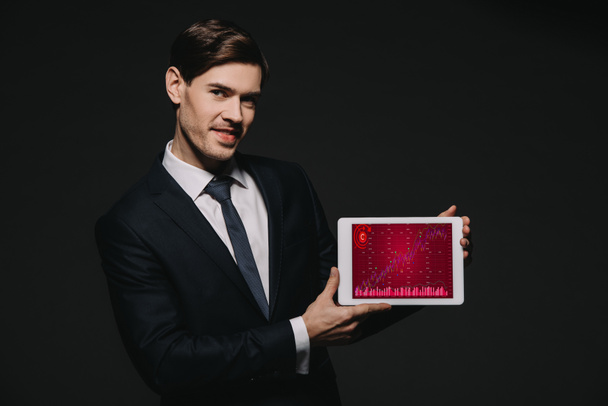 веселый бизнесмен держит цифровой планшет с красными технологическими элементами на экране изолированы на черном
 - Фото, изображение