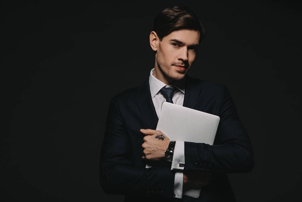 homme d'affaires en tenue formelle tenant tablette numérique dans les mains isolées sur noir
 - Photo, image