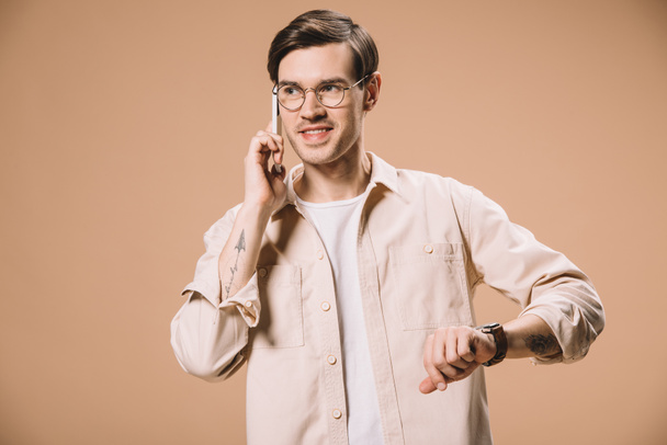 cheerful man in glasses talking on smartphone isolated on beige  - Photo, Image