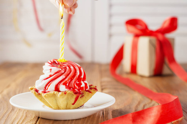 Cupcake et cadeau d'anniversaire. Gâteau d'anniversaire coloré avec bougie. Délicieux cupcake sur table en bois
. - Photo, image