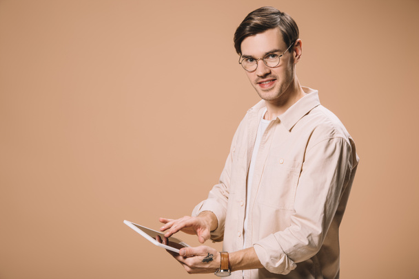 cheerful man in glasses using digital tablet isolated on beige  - Foto, imagen