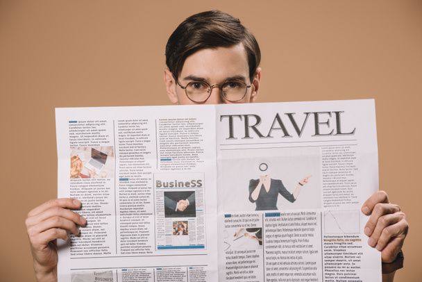  człowiek w okularach, trzymając gazetę podróży na beżowym tle  - Zdjęcie, obraz