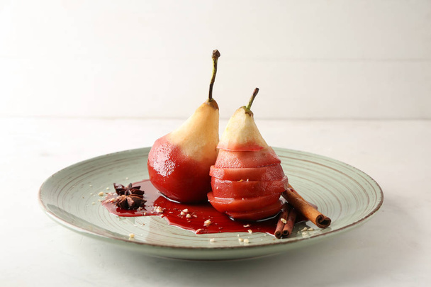 Plate with sweet pears stewed in red wine on white table - Фото, изображение