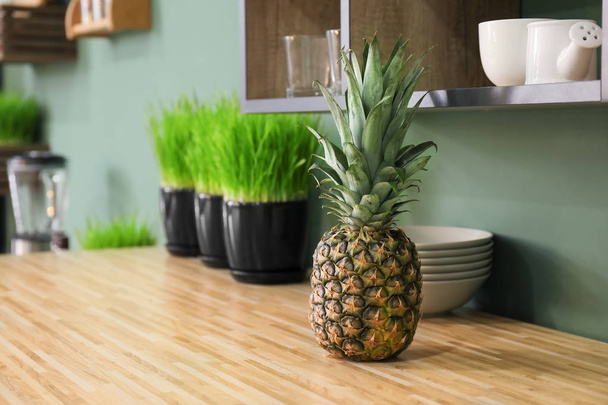 Fresh pineapple on table in modern kitchen - Φωτογραφία, εικόνα