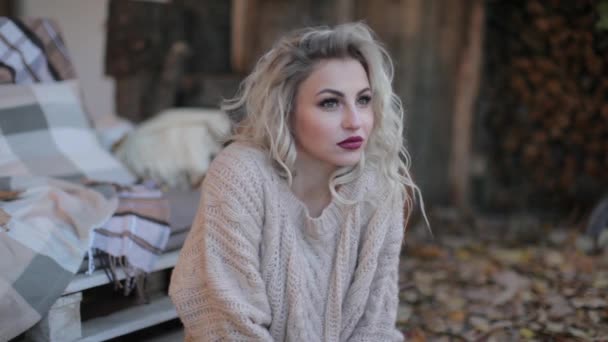 Szőke lány egy bézs színű pulóver a fotózást - Felvétel, videó