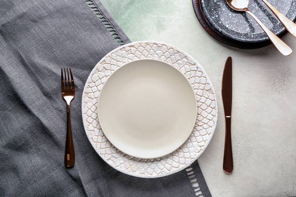 Stylish plates with cutlery on light background - Фото, зображення