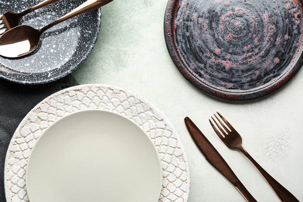 Stylish plates with cutlery on light background - Fotografie, Obrázek