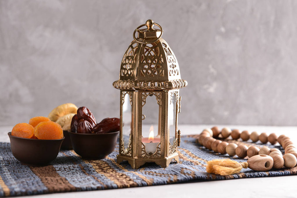 Muzułmańskich Latarnia z modlitwy paciorki i suszone owoce na stole - Zdjęcie, obraz