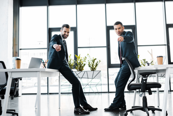 businessmen in formal wear pointing with fingers in modern office  - Photo, Image