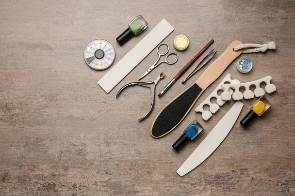 Set di strumenti professionali per pedicure e smalti su sfondo grigio
 - Foto, immagini
