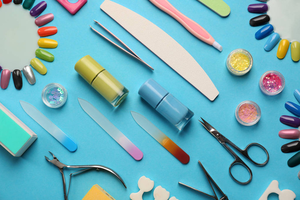 Набор профессиональных инструментов для педикюра и лака для ногтей на цветном фоне
 - Фото, изображение