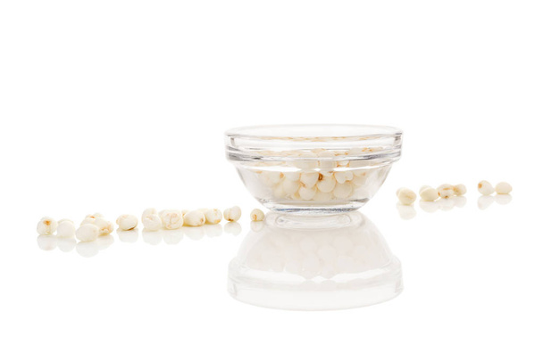 Сухе насіння лотоса в мисці ізольовано на білому тлі. Багаті білками, вітамінами та дієтичними мінералами
. - Фото, зображення