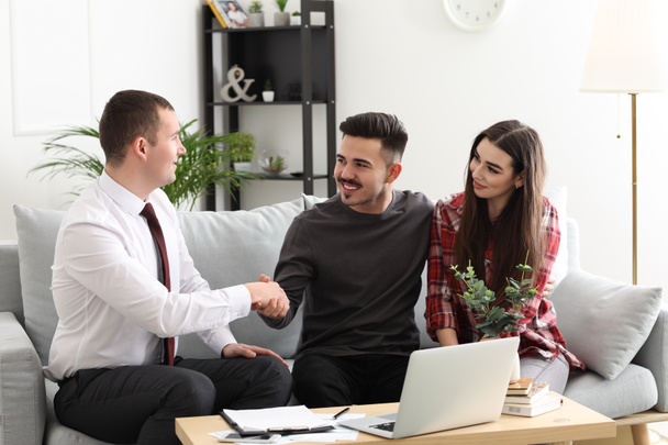 Young couple concluding agreement with insurance agent at home - Photo, Image
