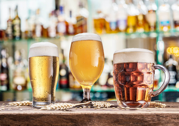 Glasses of beer on the wooden table. Blurred pub interior at the background. - Photo, image