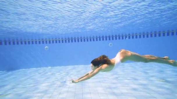 Atractiva mujer nadando en la piscina en cámara lenta
 - Imágenes, Vídeo