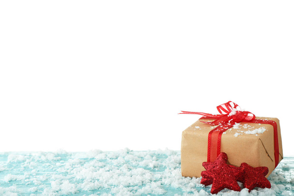 Christmas gift and snow on table against white background - Photo, Image